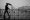 Guy_with_an_umbrella_battling_rain_and_snow_on_a_bridge